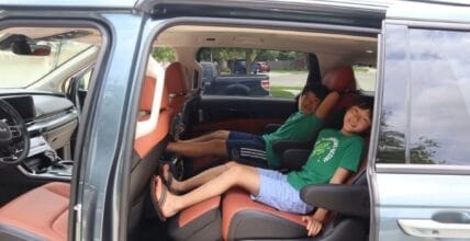 Two Kids In The Second Row Of The Kia Carnival Mpv