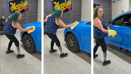 Green Haired Woman Wipes A Car With A Yellow Cloth.