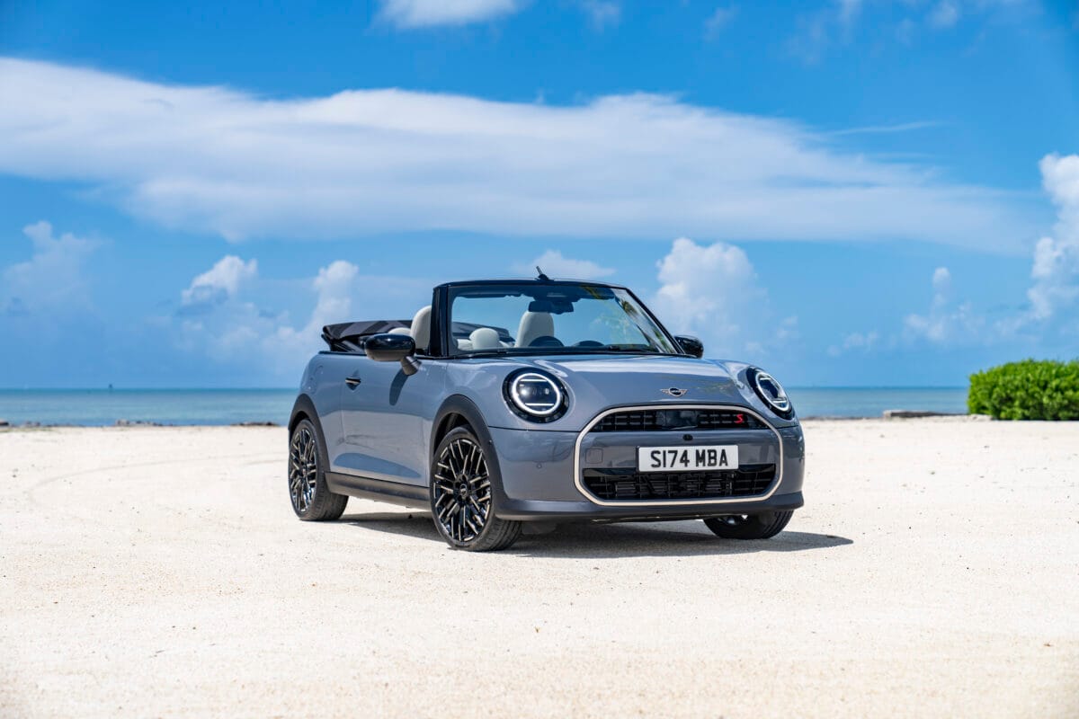 A 2025 Mini Cooper With The Optional Convertible Top Sitting On A Beach With The Top Down