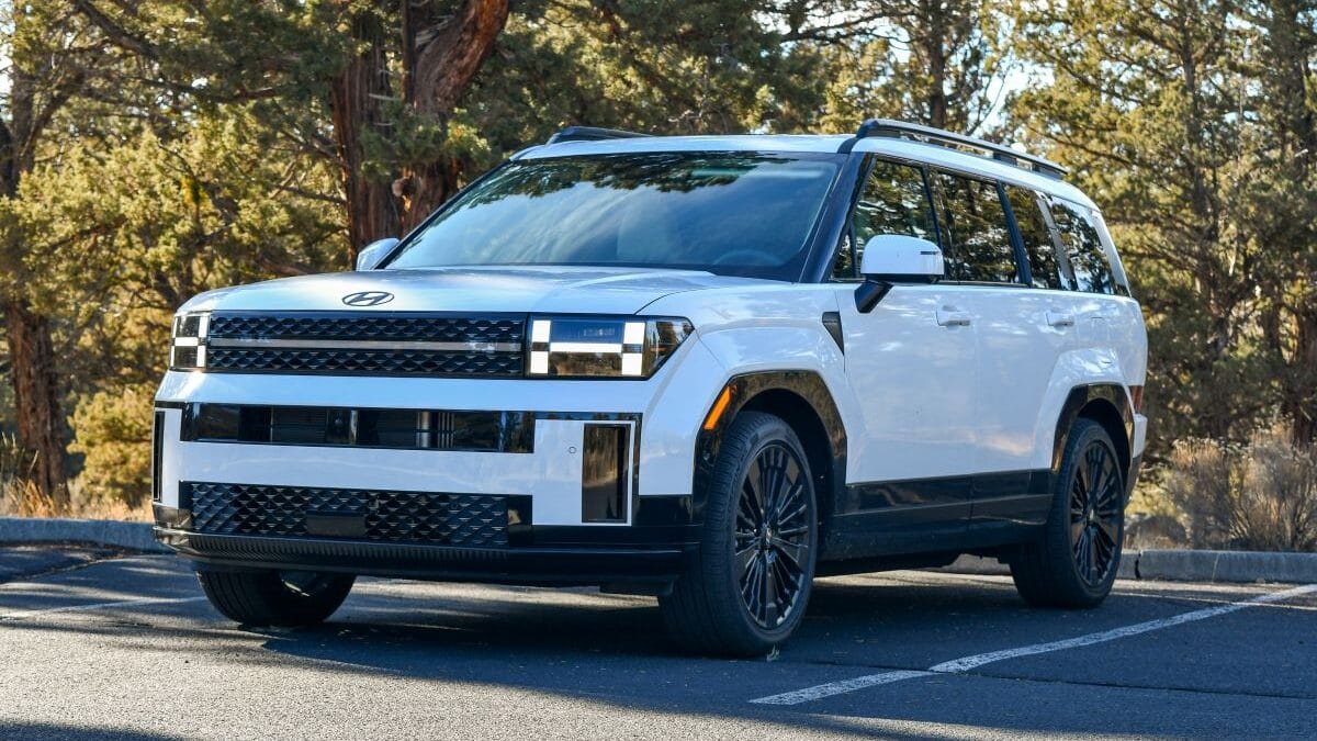The 2024 Hyundai Santa Fe Hybrid Parked In A Shady Spot With Green Trees In The Background