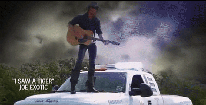 Tiger King Joe Exotic standing on the hood and singing