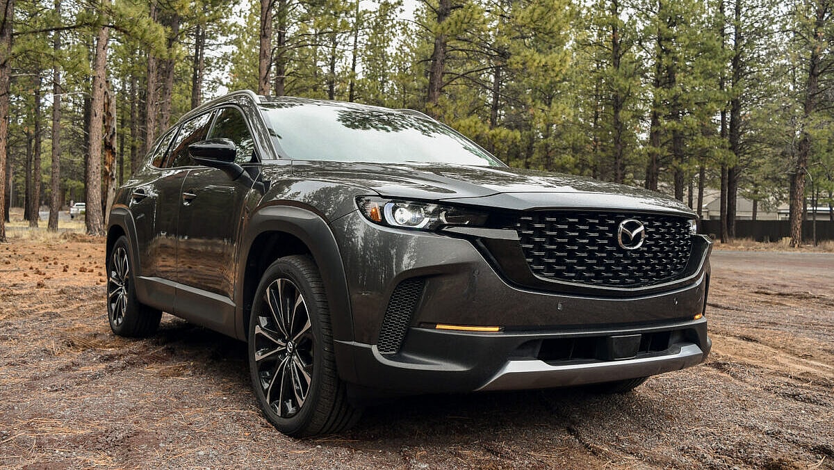 The 2025 Mazda CX-50 2.5 Premium Plus parked on a dirt wood surrounded by trees
