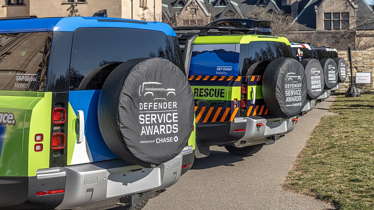 Land Rover Defender Service Award trucks in a line