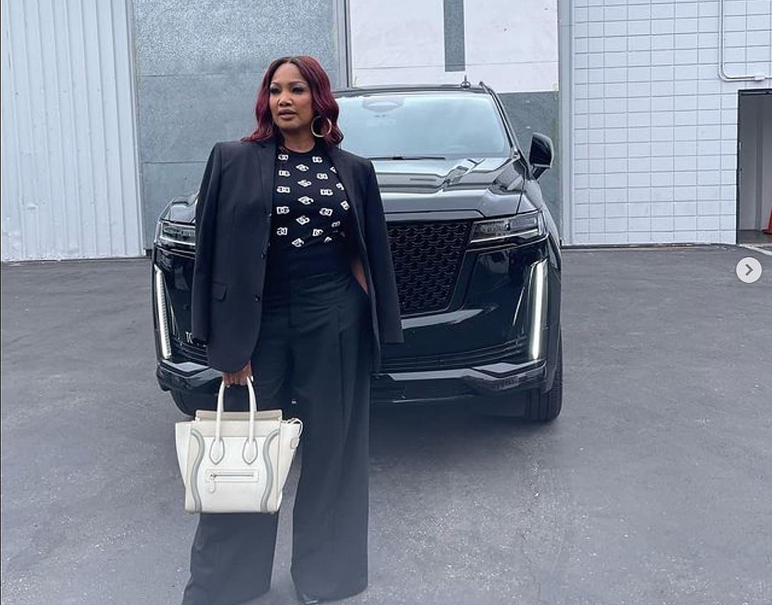 Garcelle Beauvais And Her Cadillac Escalade, Posed For A Picture With A Designer Bag