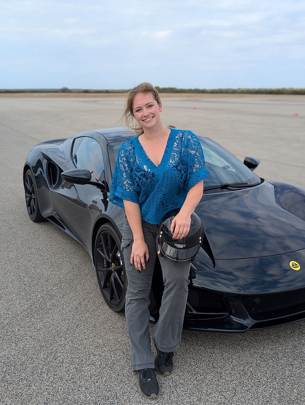 I Went to Tire Testing School With Discount Tire's Treadwell Team and Was Shocked At What I learned 11 Annika Sitting On A Lotus Emira Holding A Helmet Before Testing Tires At The Treadwell Experience
