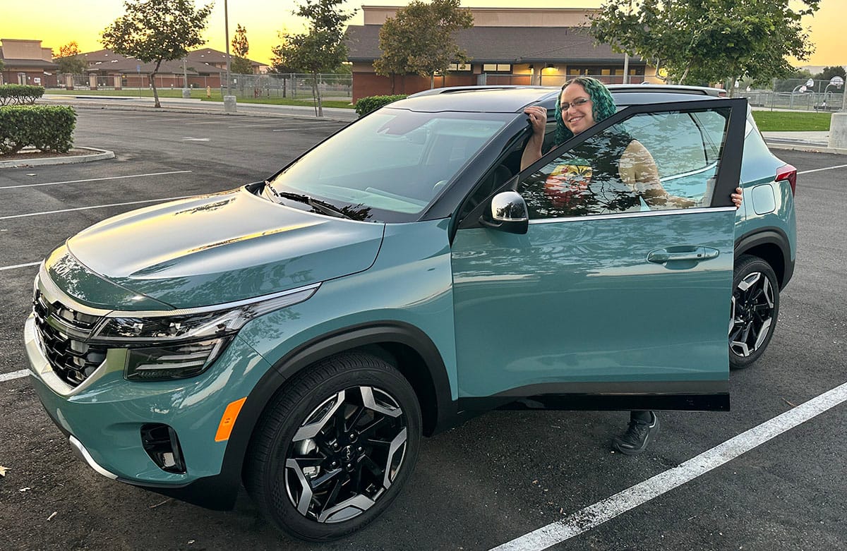 Featured Image - Liv Leigh smiles while hopping into the 2024 Kia Seltos SX Turbo safest cars on the road upside down car loan best SUV under $30,000