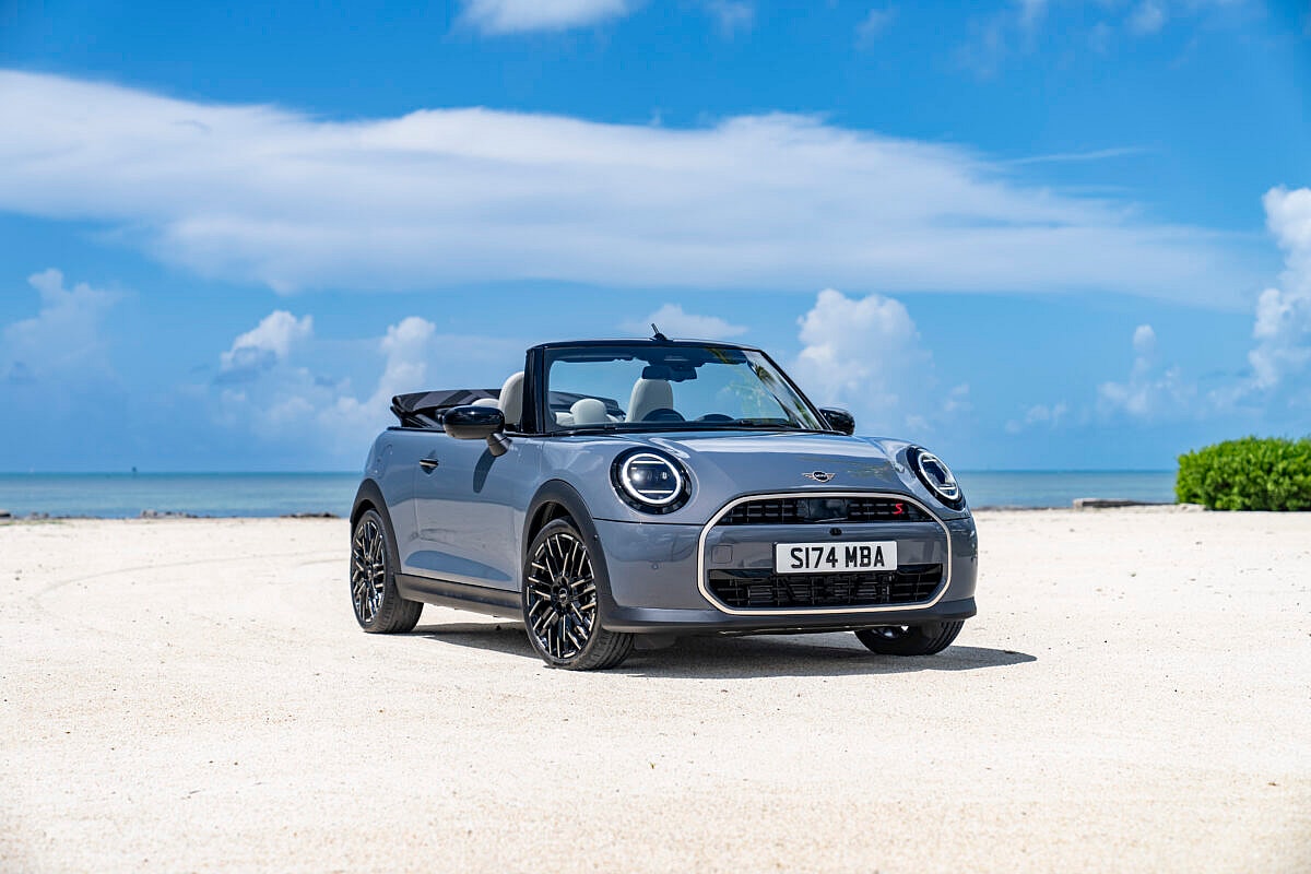 A 2025 Mini Cooper With The Optional Convertible Top Sitting On A Beach With The Top Down