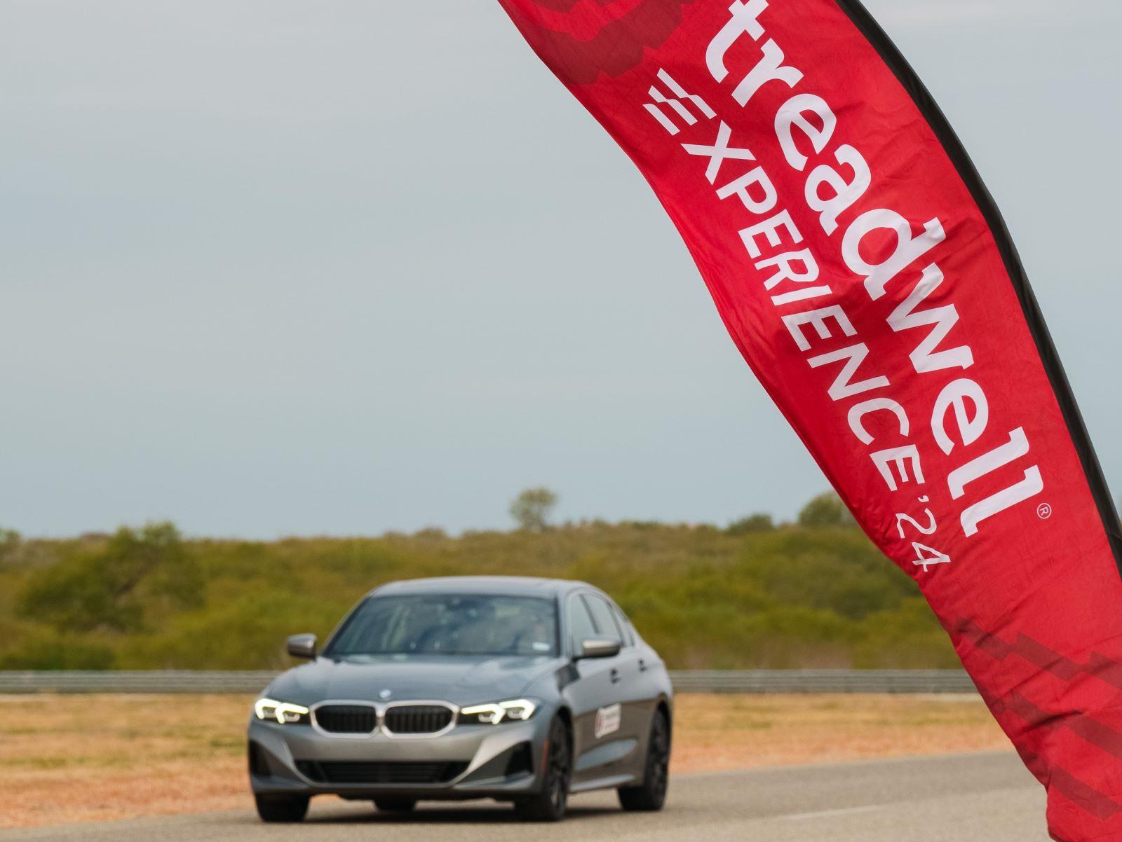 A Bmw 3-Series Crosses The Finish Line As Part Of Testing The Effectiveness Of Different Tire Types On Varying Surfaces