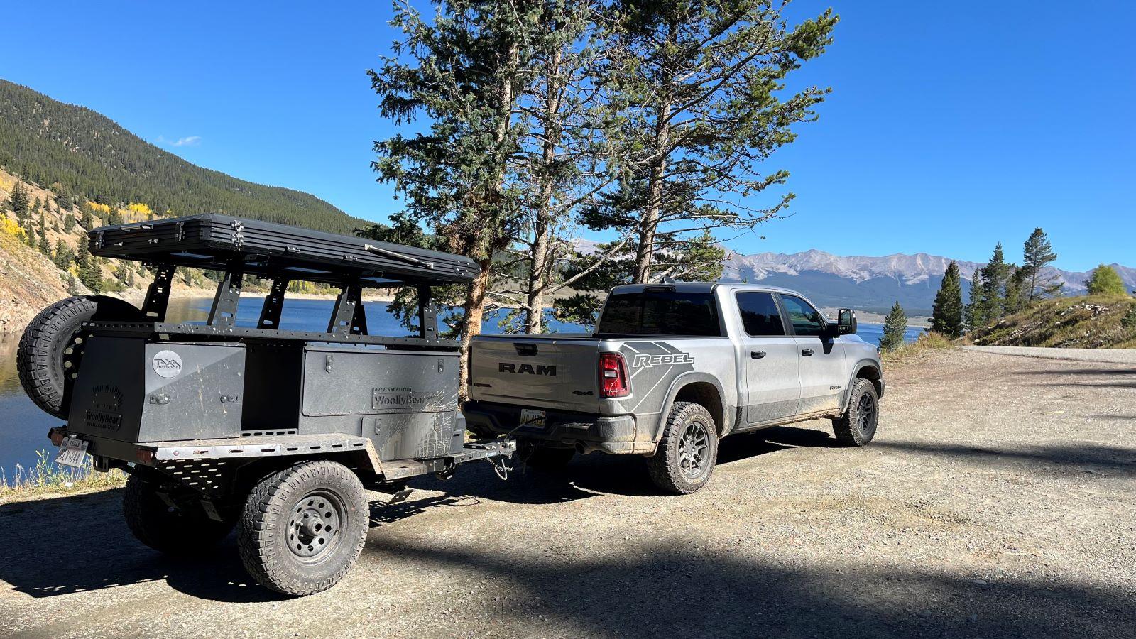 The Ram Rebel Towing The Taxa Woolly Bear Camping Trailer, Parked Near A Lake