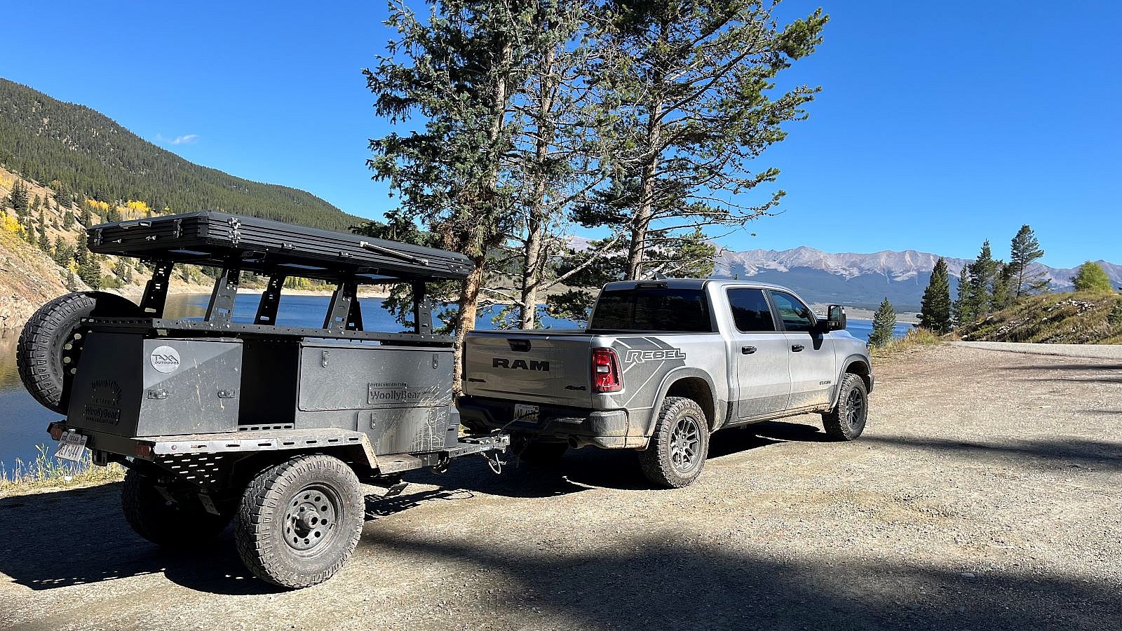 The Ram Rebel Towing The Taxa Woolly Bear Camping Trailer, Parked Near A Lake