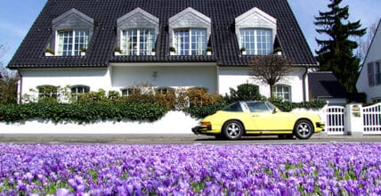 Bright Yellow Porsche Parked Near Blooming Crocus Flowers
