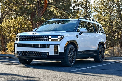 The 2024 Hyundai Santa Fe Hybrid Review: This Car is So Good My Husband Wants One ASAP 7 The 2024 Hyundai Santa Fe Hybrid Parked In A Shady Spot With Green Trees In The Background