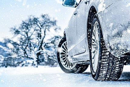 A Car With Snow Tires Is Parked On Ice To Show Tread Depth And Tire Detail