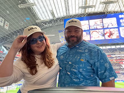 Natalie Merola And Her Husband At A Fifa World Cup Game Wearing A Kia Hat