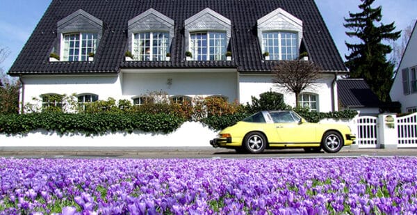Bright Yellow Porsche Parked Near Blooming Crocus Flowers