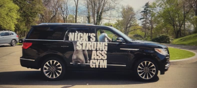 A Lincoln Navigator Emblazoned With The Nick'S Strong Ass Gym Branding In Your Friends And Neighbors