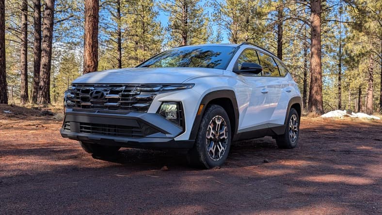The 2025 Hyundai Tucson Parked On A Dirt Road With A Wooded Background