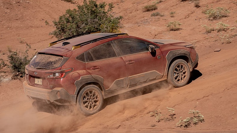 The Side Of The 2024 Subaru Crosstrek Going Up The Side Of A Sandy Hill