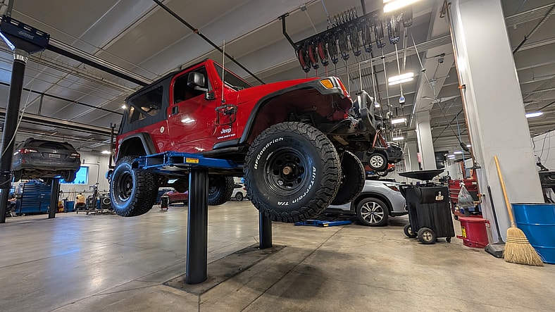 7 Reasons You Should Go To a Car Dealer Service Department—and What to Know Before Approving Work 8 My Jeep On A Dealership'S Lift To Have Tires Installed