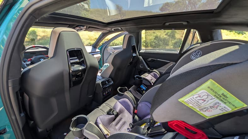 Why Do So Many People Love the 2025 BMW M5 PHEV Touring Wagon? I Reviewed it and Now, I Get It 6 The Second Row Of The 2025 Bmw M5 Touring Wagon, Showing My Daughter'S Car Seats