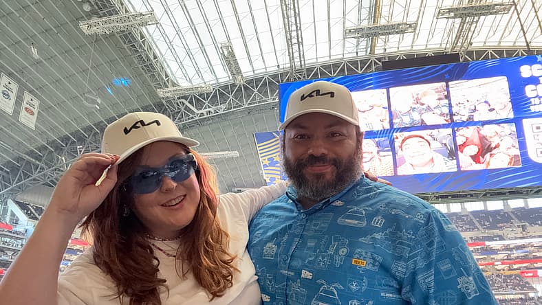 Natalie Merola And Her Husband At A Fifa World Cup Game Wearing A Kia Hat