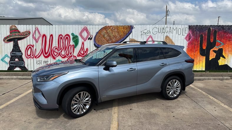 Driving the 2024 Toyota Highlander Hybrid Brought Pleasant Memories Back to the Surface 2 A 2024 Toyota Highlander Hybrid Parked In Front Of Tasteful Texican Graffiti Most Affordable 3 Row Suvs