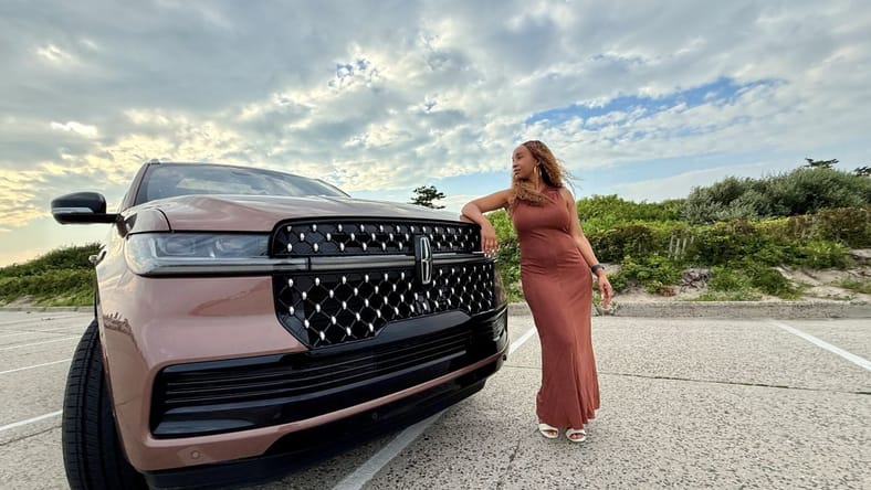 Kim Smith Standing Next To A Lincoln Navigator Black Label