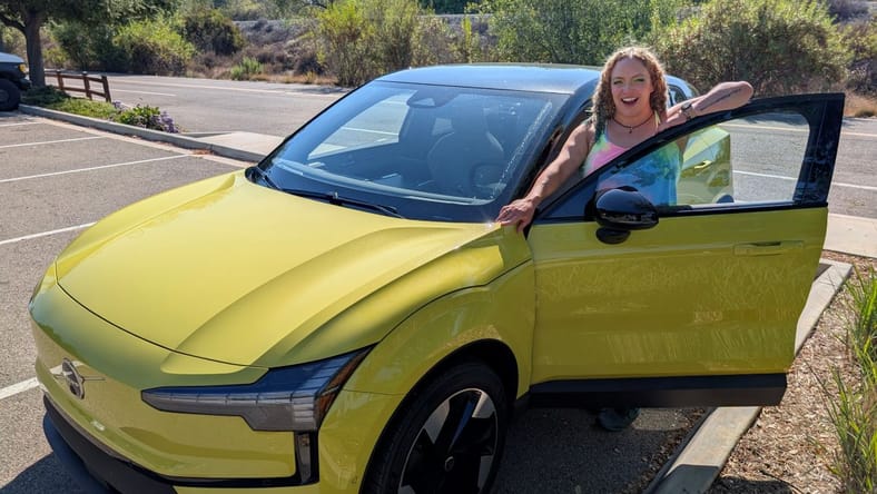 The Volvo EX30 Proves You Don't Need to Be Big to Stand Out 2 Liv Standing With The 2025 Volvo Ex30 In Moss Yellow
