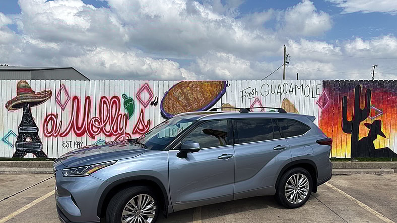 A 2024 Toyota Highlander Hybrid Parked In Front Of Tasteful Texican Graffiti Most Affordable 3 Row Suvs