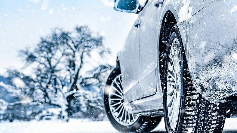 A Car With Snow Tires Is Parked On Ice To Show Tread Depth And Tire Detail