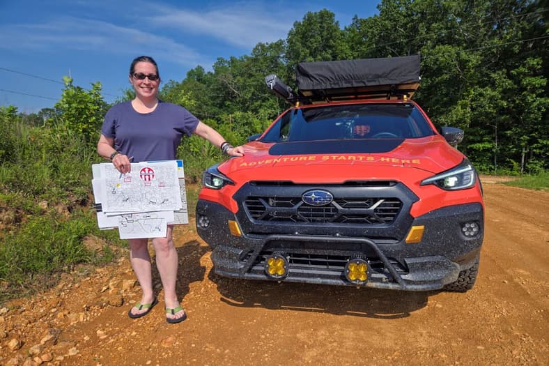 Mercedes Standing Next To The Updated Crosstrek Wilderness, Maps In Hand