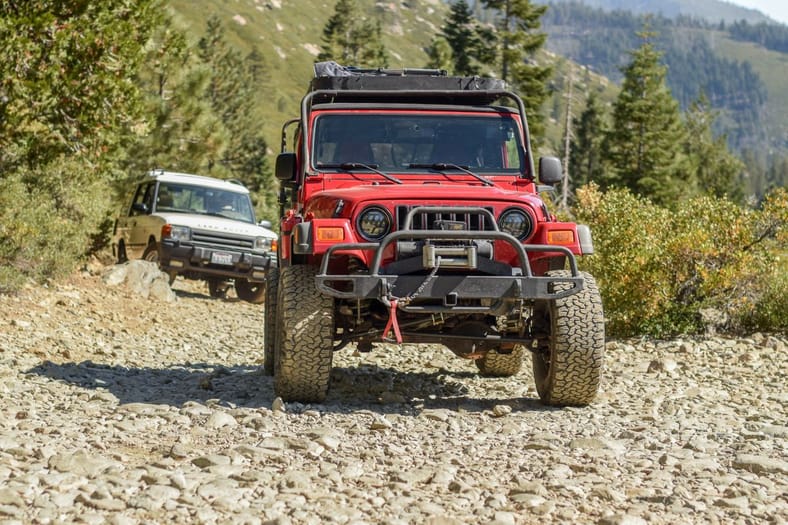 A 2006 Jeep Wrangler And A 1996 Land Rover Discovery Traversing A Trail