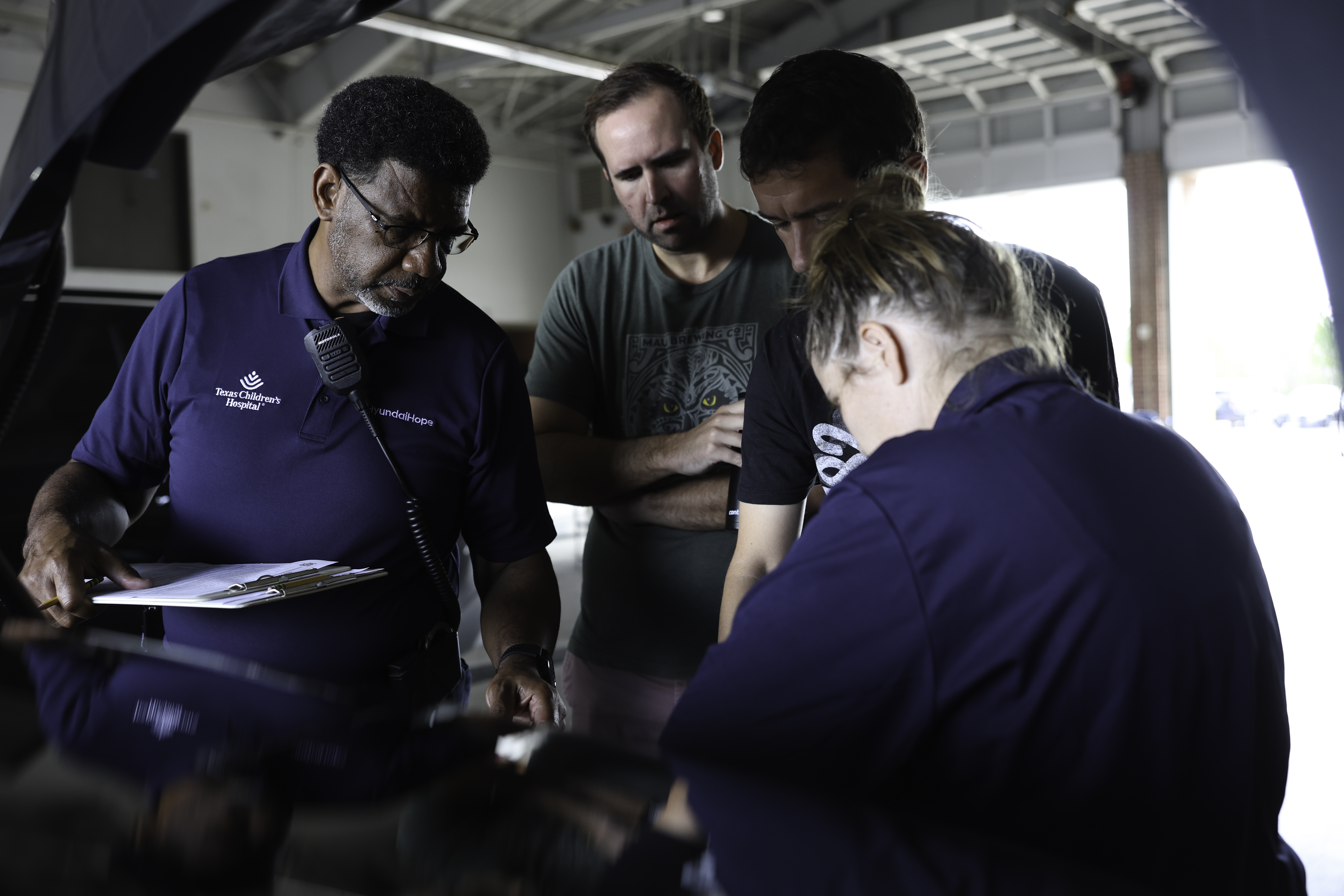 A Young Father And The Baby'S Grandfather Learning How To Secure A Child In A Car Seat