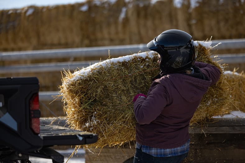 Dreaming of a Private Ranch Retreat? Dream of Bringing the 2025 Kawasaki Ridge Crew ORV Along, Too 5 Me Loading A Bale Of Hay Into The Bed Of A Kawasaki Ridge Crew