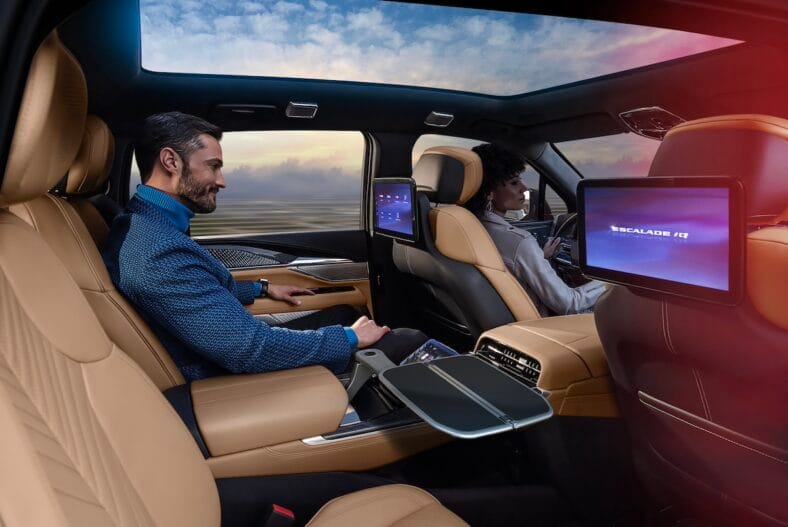 Man Sitting In Executive Second Row Of Cadillac Escalade Iq With Backseat Screens.