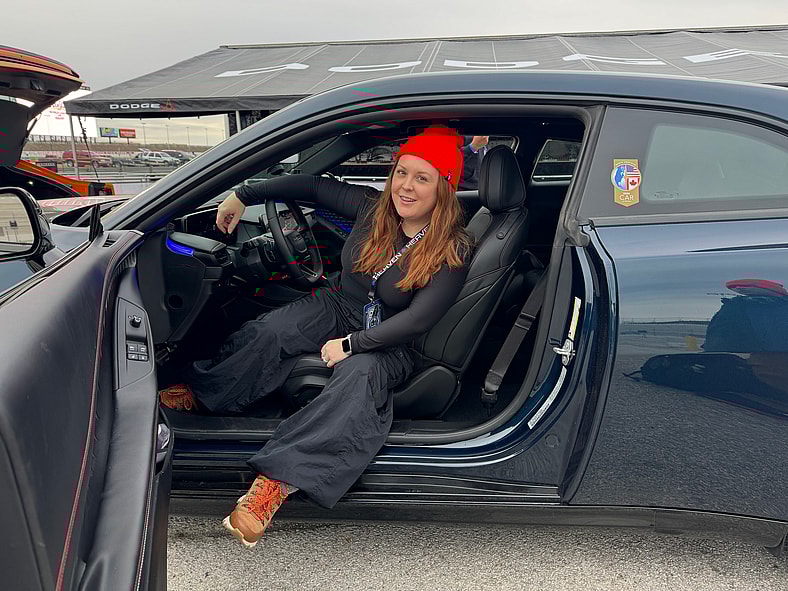 Natalie Merola Sitting In The Driver'S Seat Of A New Dodge Charger Sixpack At Mopar Heaven