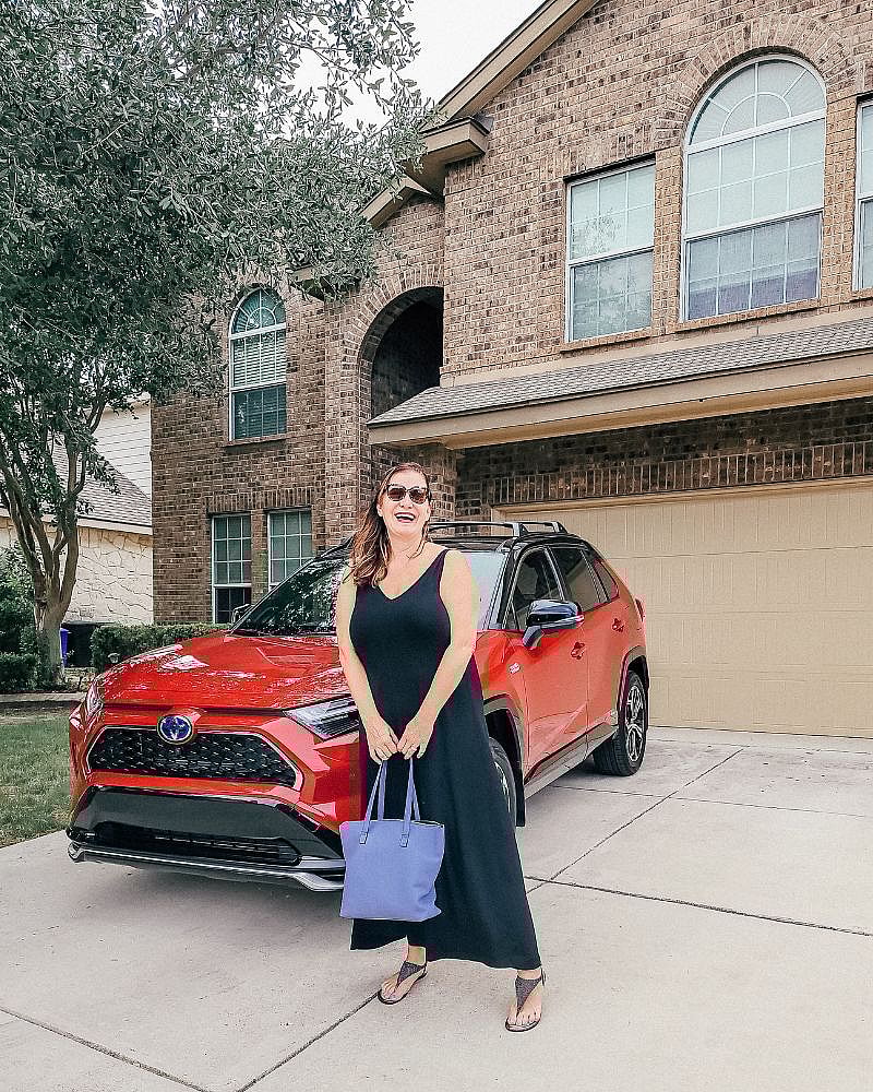 Woman In Black Dress In Front Of Red Toyota Rav4 Plug In Hybrid