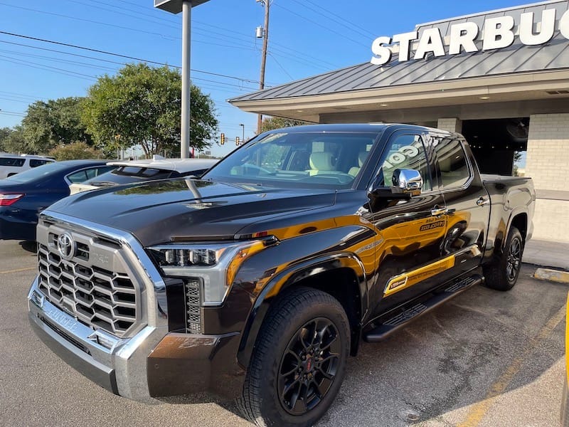 A brown Tundra hybrid truck in a parking spot 