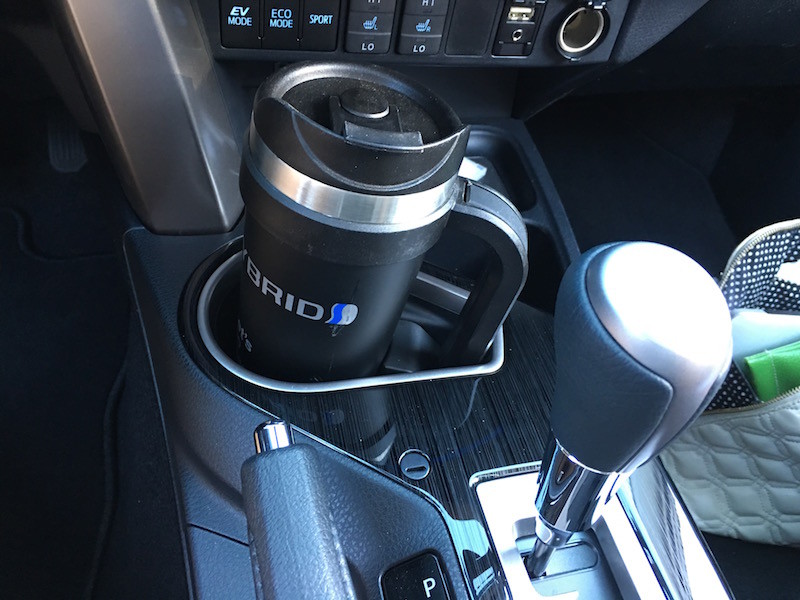A coffee mug in the front cup holder of the SUV