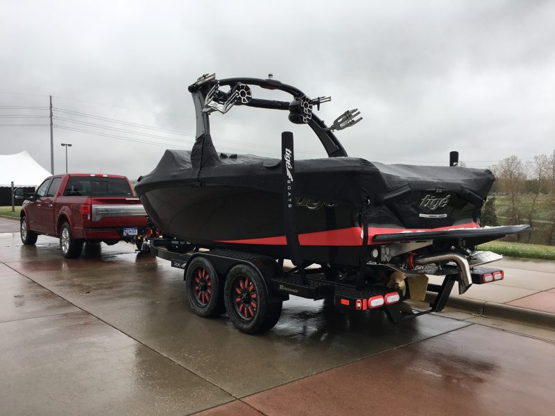 Trailering a red boat with a black cover 