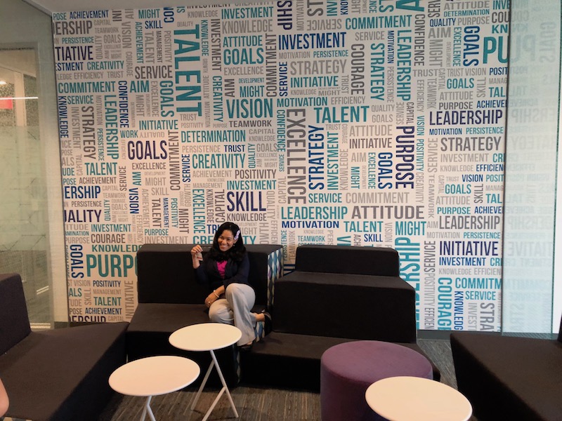 employee lounge with black couches, purple and white tables plus empowering words on the back wall 
