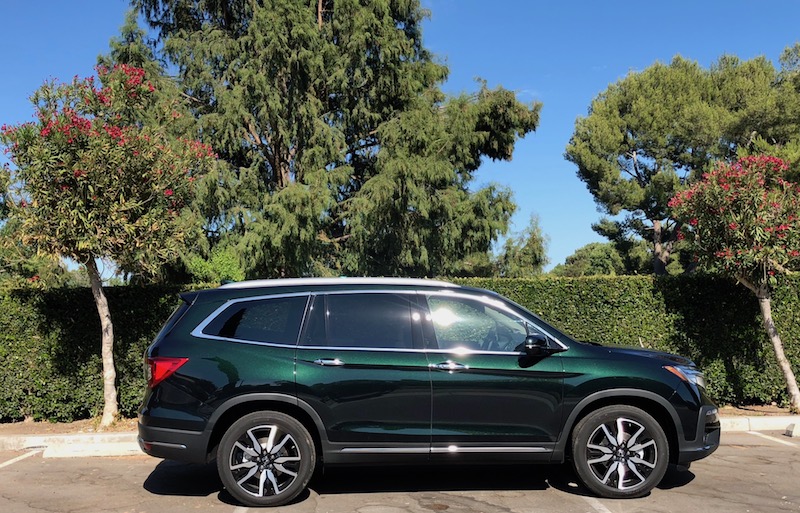 Green Honda Pilot in front of trees