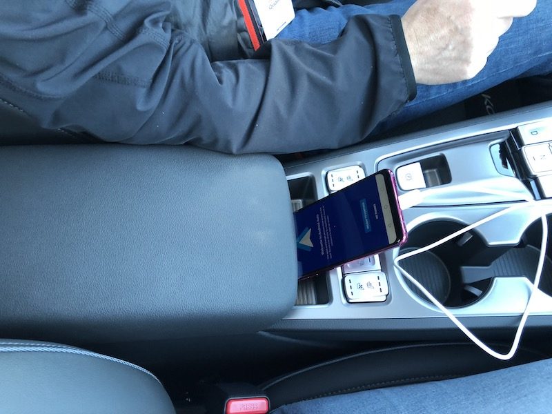 A phone plugged into the center console of the car