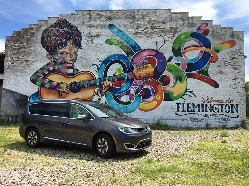 What Is The True Cost Of Hybrid Driving A S Guide To Cars Chrysler Pacifica In Front Of A Mural