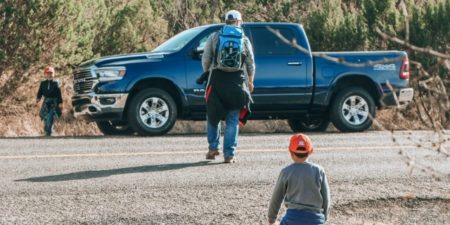 Why your new road trip car just might be a truck - review of the RAM 1500|Man walking toward a truck followed by a little boy in an orange hat
