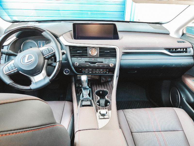 Lexus RX450hL Cabin luxury including wood steering wheel.