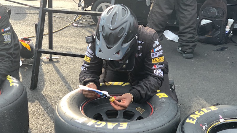 On the day of the race, Brehanna glues the tires to prepare for today's pit stops.