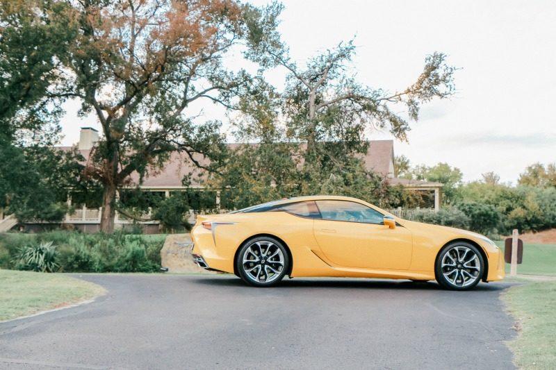 yellow sexy sports car parked in a driveway 