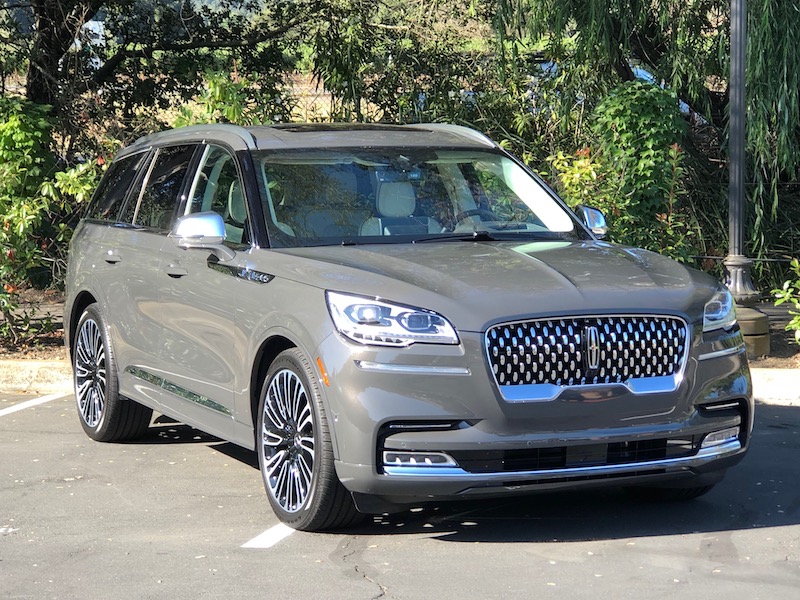 luxury three-row Lincoln Aviator parked with trees in the background