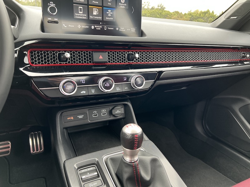 The command center in the 2022 Honda Civic Si with the manual shifter, drivce mode selector and phone storage cubby